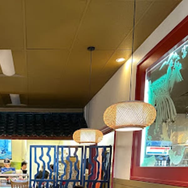 Interior of Tokyo Garden with bamboo pendant lights, blue screens, and a red-framed window.